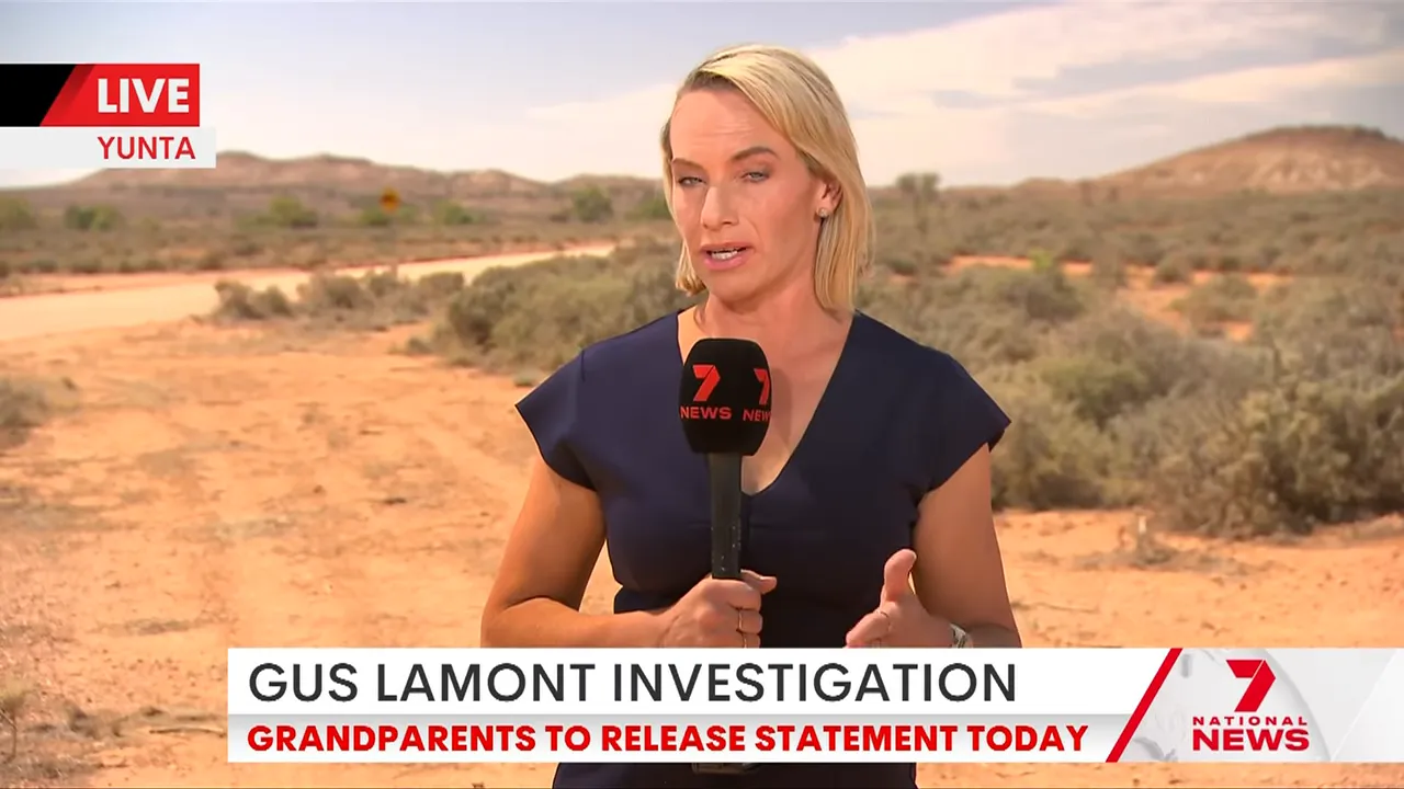 On-location reporter in an arid outback holding a microphone; chyron reads 'Gus Lamont investigation'.
