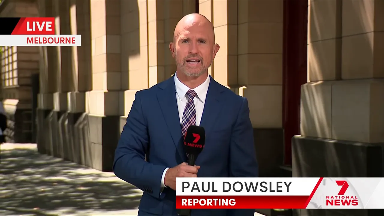 On-location news reporter holding a microphone, standing in front of a stone courthouse facade with a 'LIVE Melbourne' graphic.
