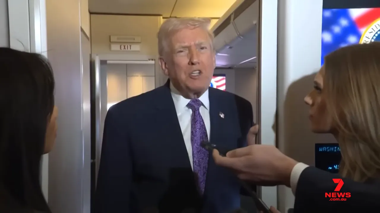 President standing in airplane doorway speaking to reporters, well-framed and in focus