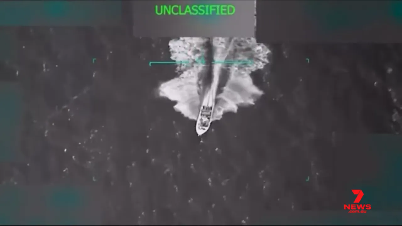 aerial infrared top-down image of a small vessel leaving a wake, marked 'UNCLASSIFIED'