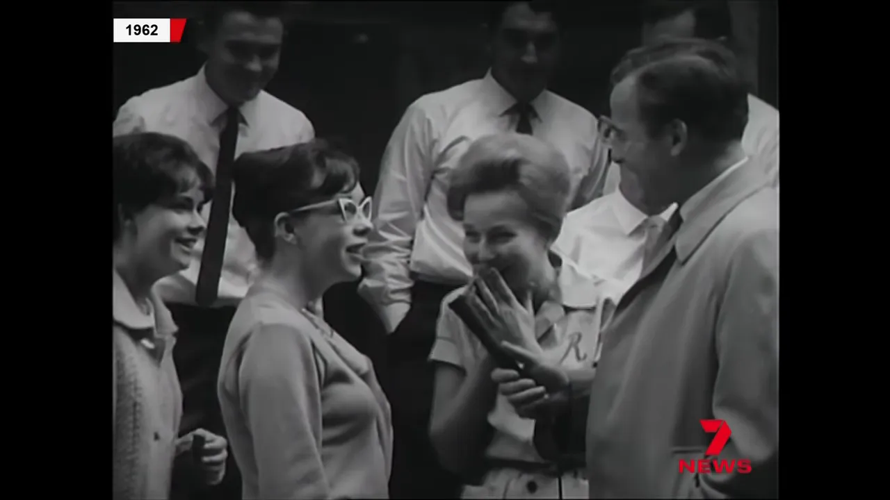 1962 black-and-white news footage of lottery winners smiling and speaking with a presenter holding a microphone