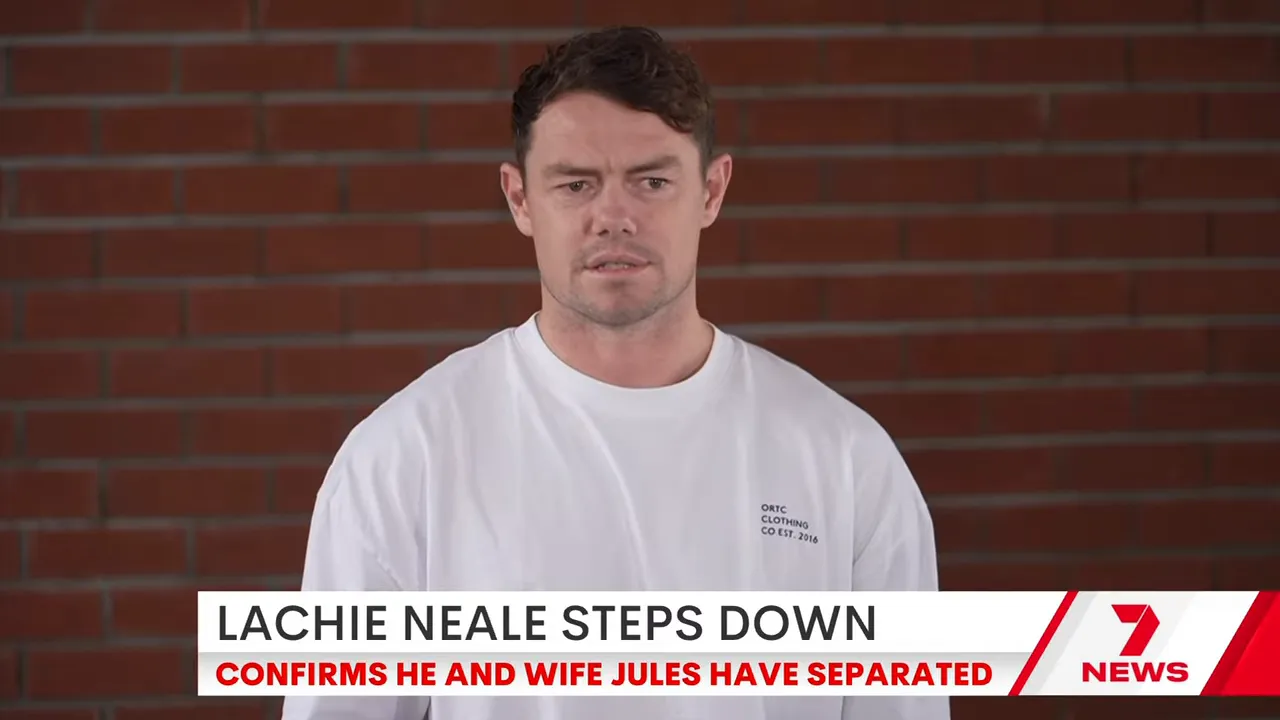 Frontal shot of a man delivering a prepared statement in front of a brick wall with a news headline banner at the bottom.