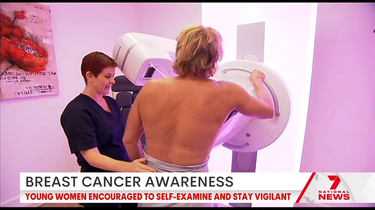 Patient being positioned at a mammography machine with a radiographer assisting