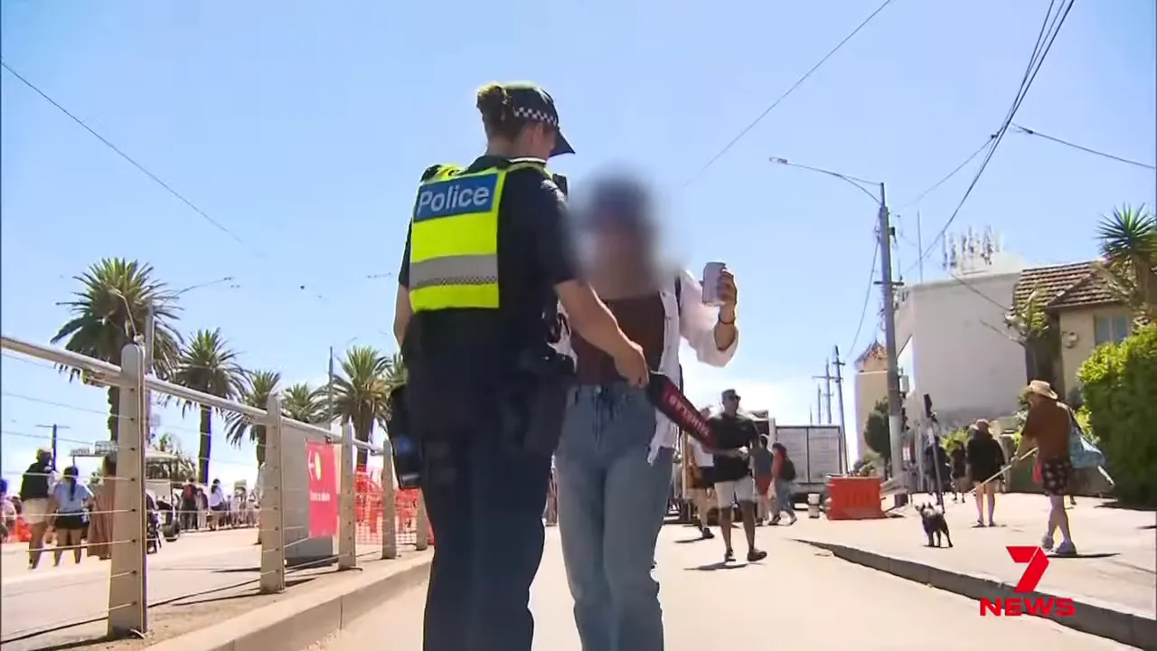 police officer using a handheld wand to scan a person in a public area