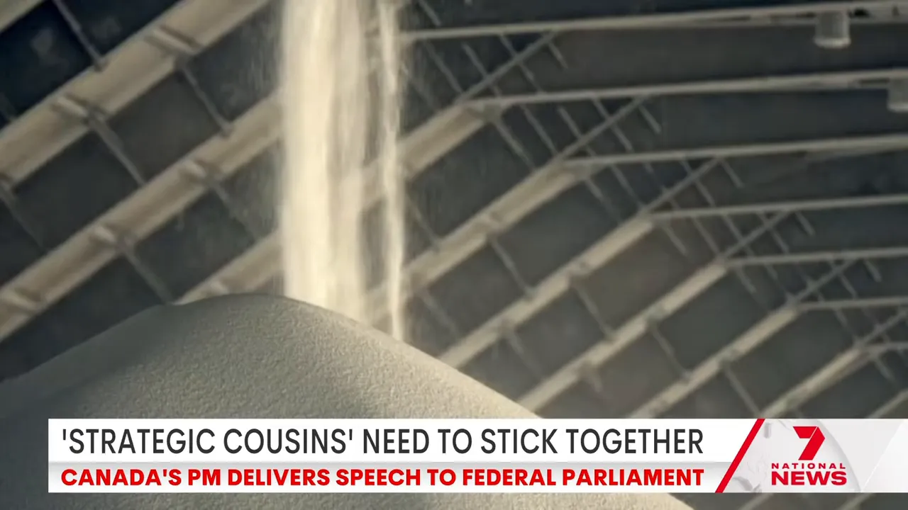 Close-up of granular fertiliser being poured into a large storage pile at an industrial facility.