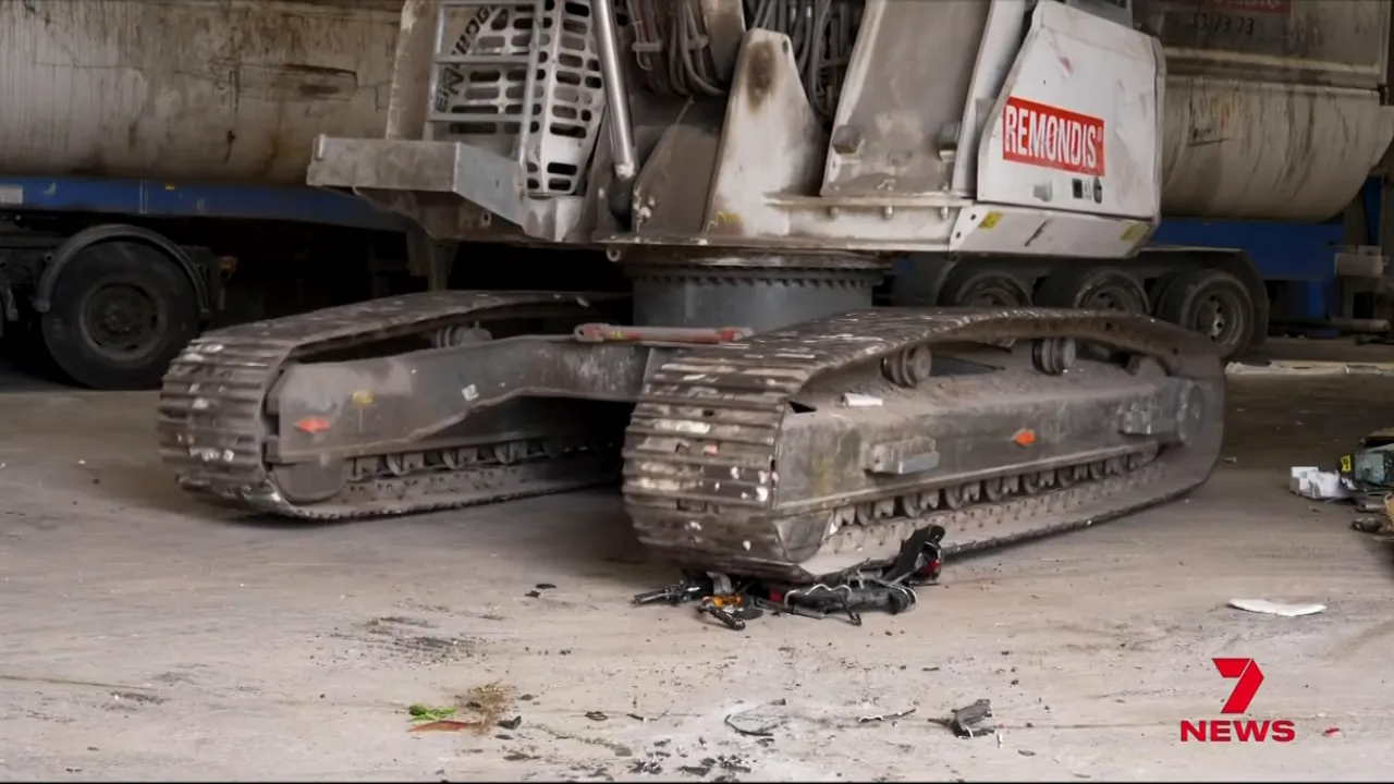 Crushed electric bike debris under excavator tracks at a depot following seizure