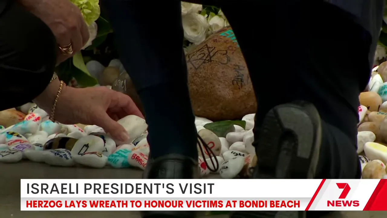 Close-up of white remembrance stones being placed among pebbles at the Bondi memorial