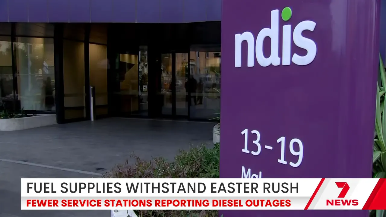 NDIS signage outside a building during news coverage linking fuel crisis to cost-of-living and budget scrutiny