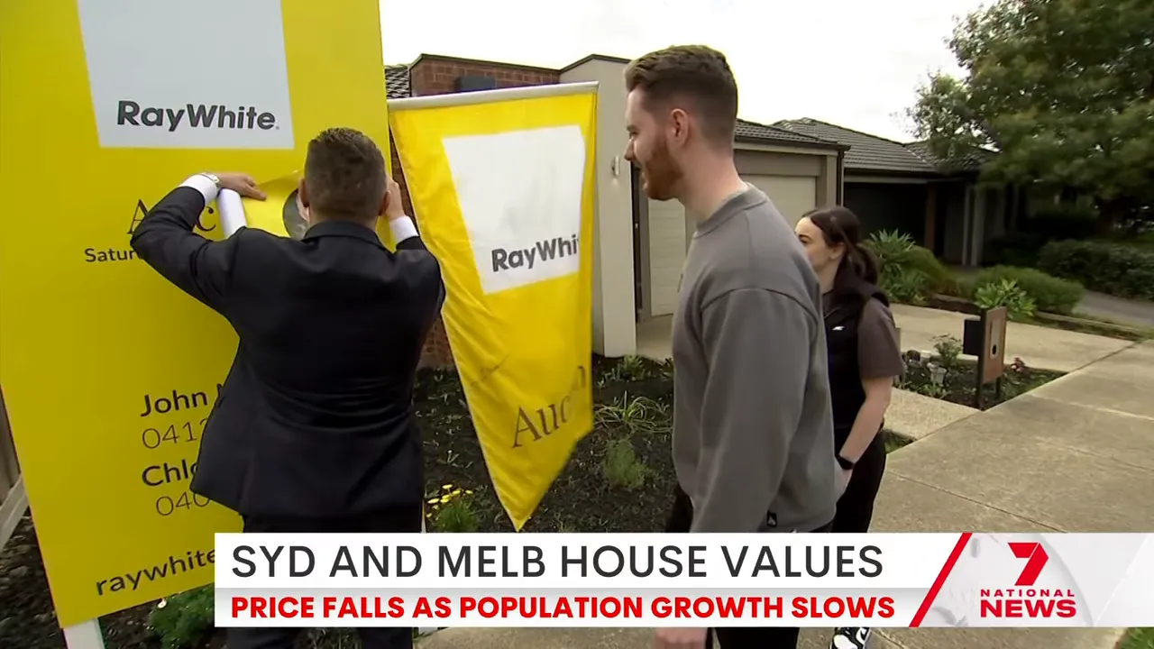 Real estate agent installing property signage outside a home in Sydney and Melbourne house price coverage