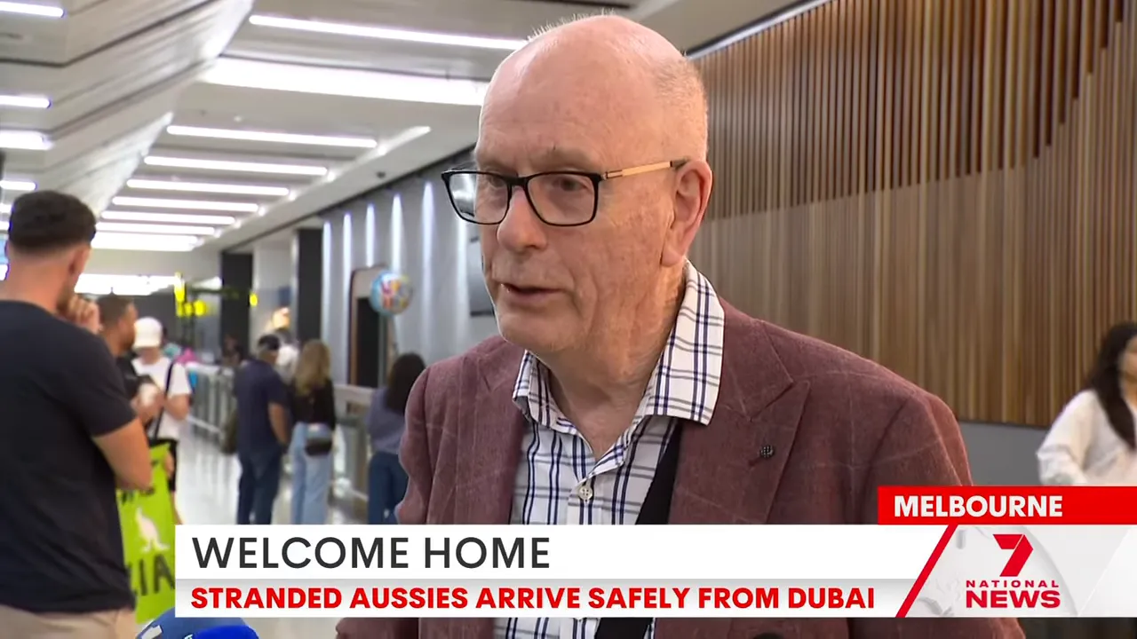 Passenger speaking to a reporter in Melbourne airport arrivals, clearly framed and well-lit