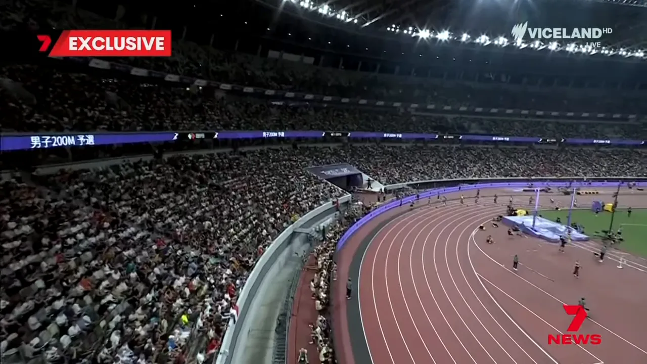 Wide-angle view of a packed athletics stadium and running track during a championship meet