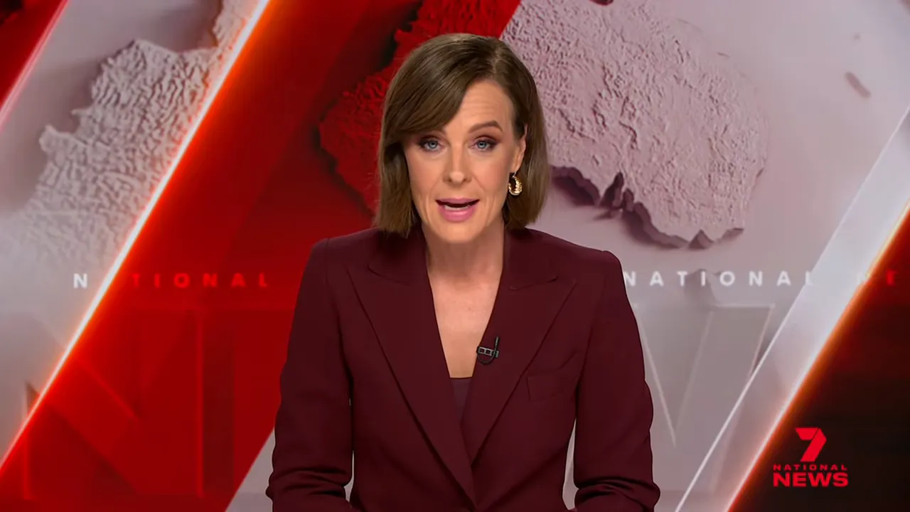 Television news anchor in a red studio set delivering the lead to a political story.