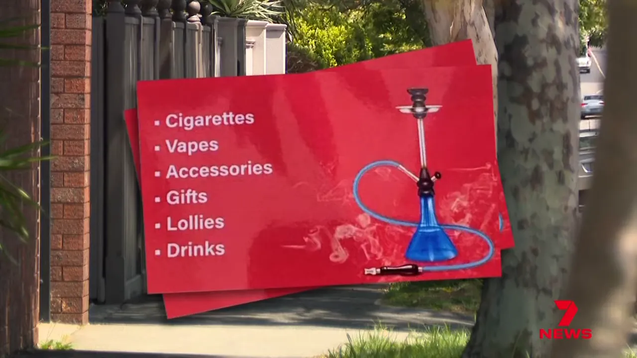 Red flyer on a suburban street listing cigarettes, vapes, accessories, gifts, lollies and drinks with a blue hookah illustration; clear and legible.