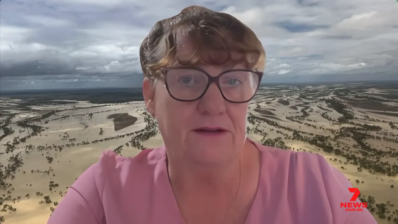 Interviewee on a video call with aerial floodplain background showing wide areas of submerged paddocks