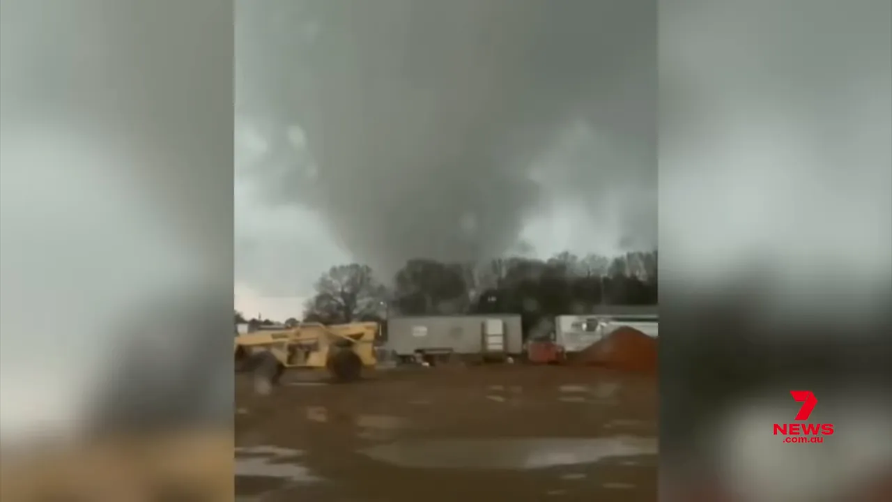 Large tornado funnel touching down near vehicles and temporary buildings at a worksite