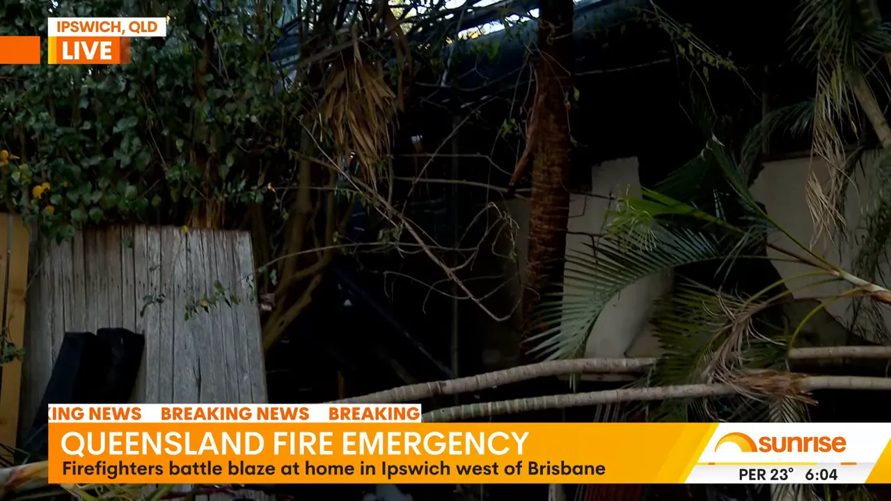Firefighters at the charred remains of a house in Ipswich after roof collapse
