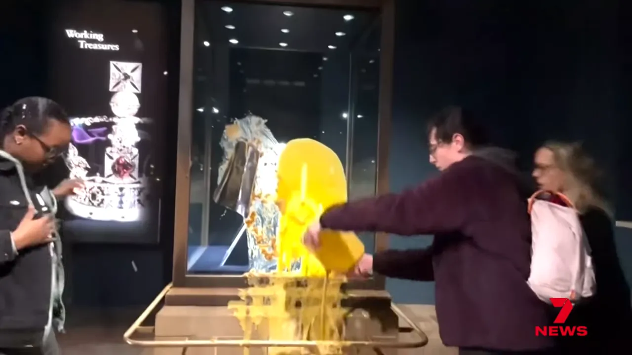 Protester pouring yellow custard over the glass case protecting the Imperial State Crown at the Tower of London