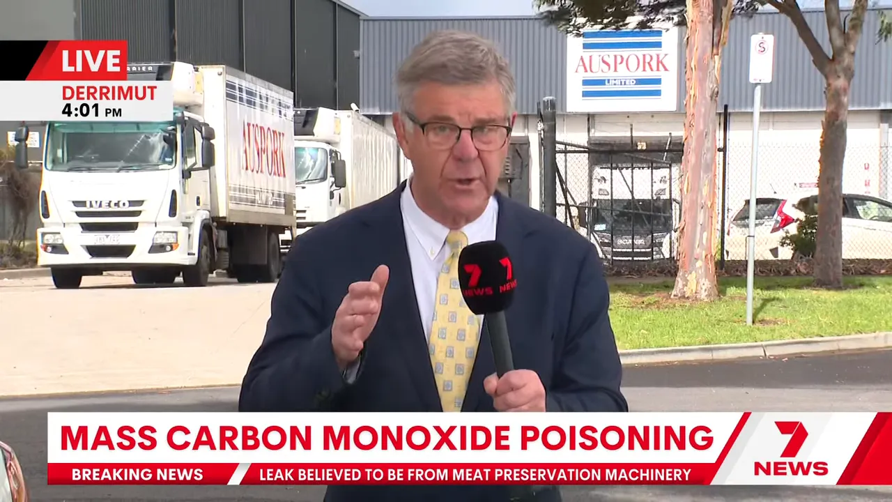 Live television reporter in front of the AusPork Derrimut facility with parked trucks and site signage, covering the carbon monoxide incident.
