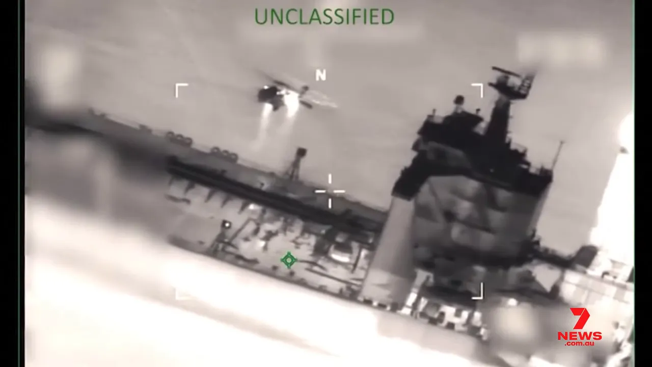 Thermal surveillance image of a helicopter approaching a ship's deck labeled 'UNCLASSIFIED' with 7NEWS watermark