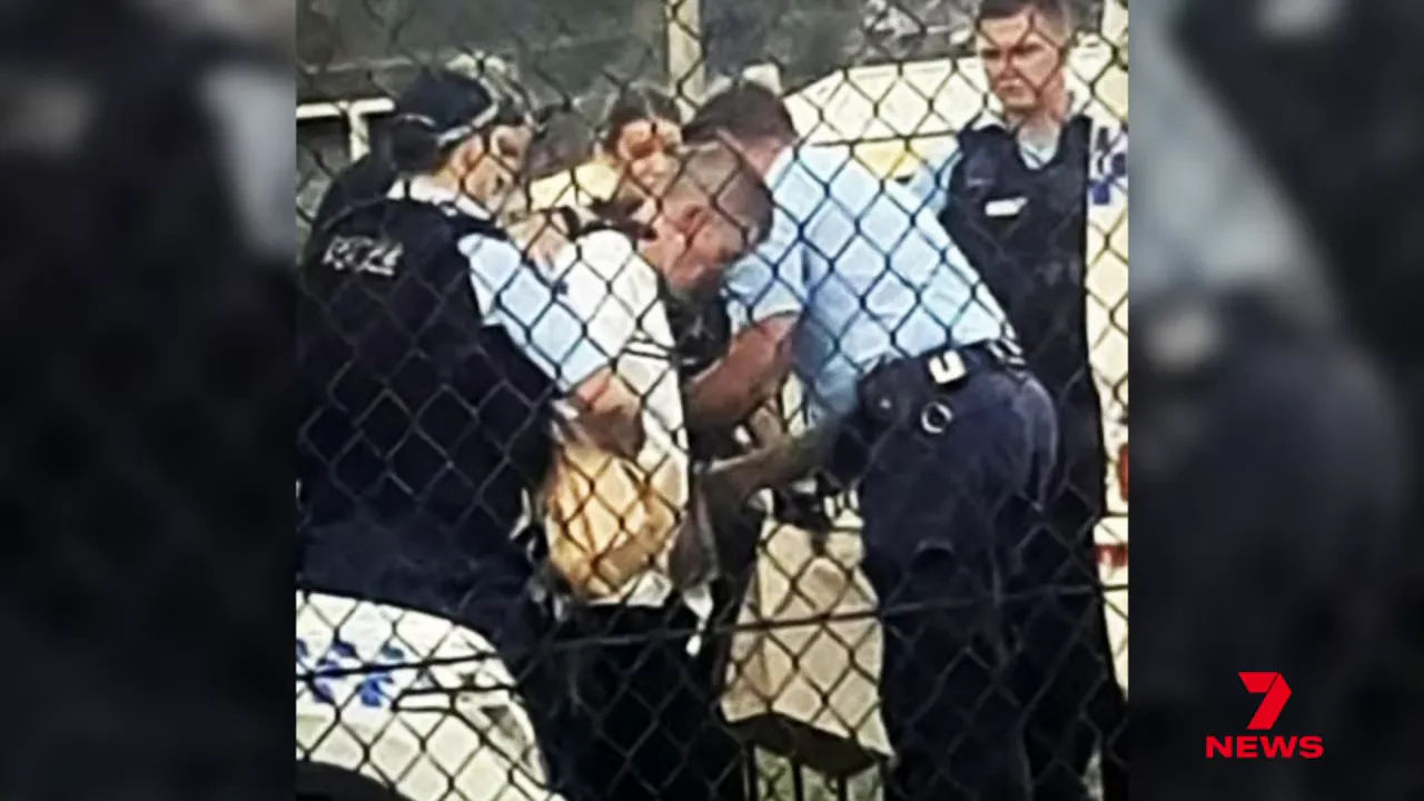 Handcuffed man held by police at the bowls club car park