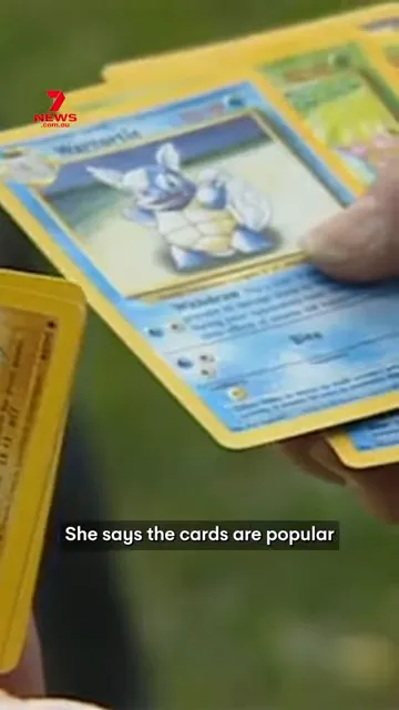Close‑up of hands holding vintage Pokémon trading cards showing a Squirtle card