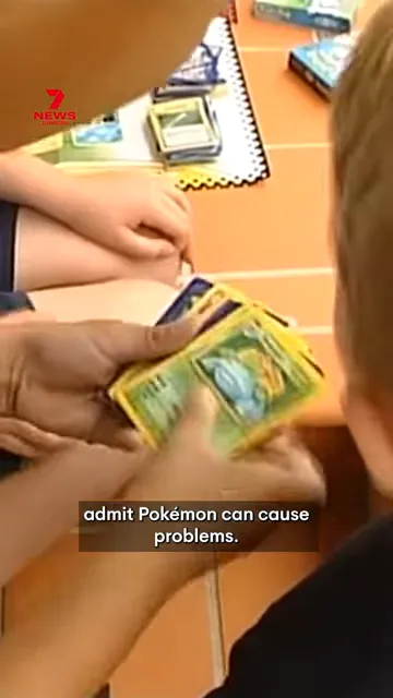 Children sitting at a school table exchanging Pokémon trading cards