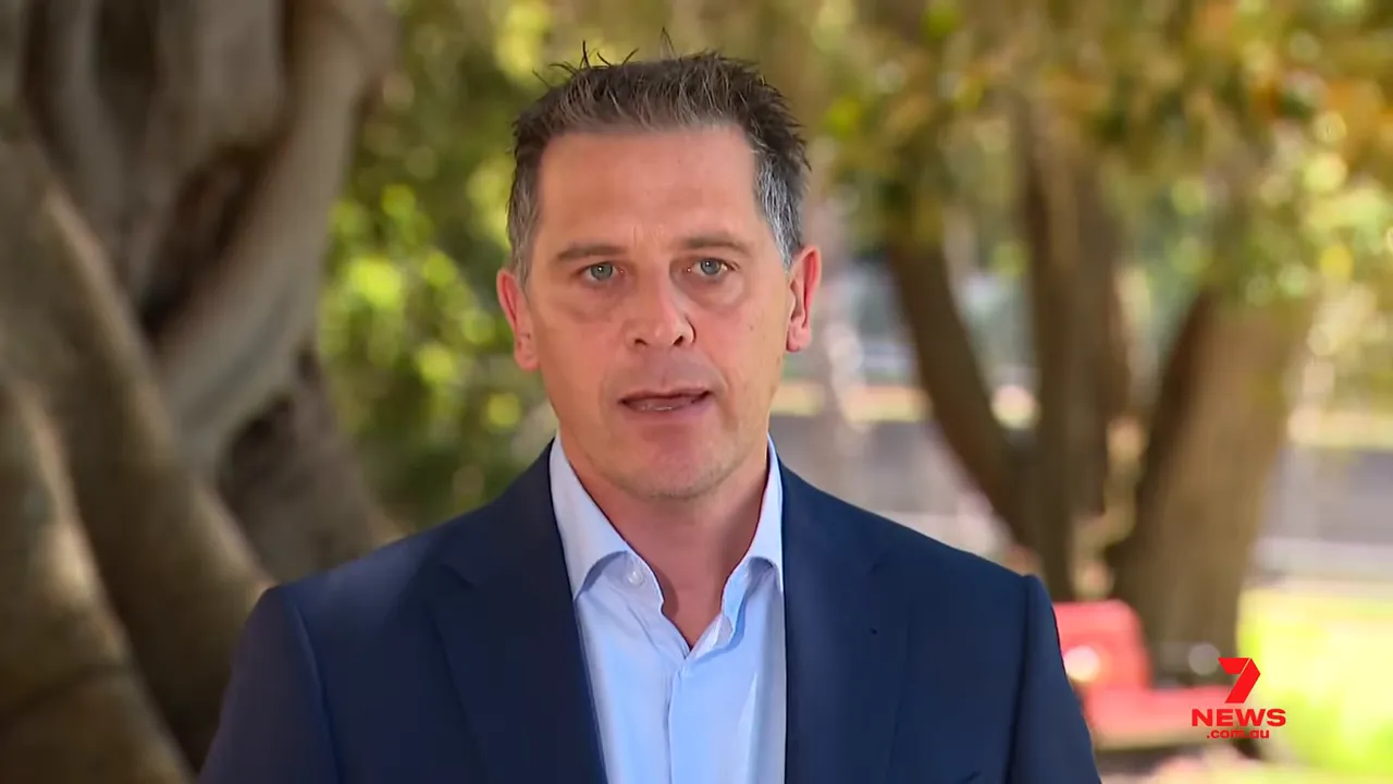 Neutral, high-quality image of a spokesperson speaking outdoors about how ambulance and health services are responding to extreme heat, 7 News logo visible