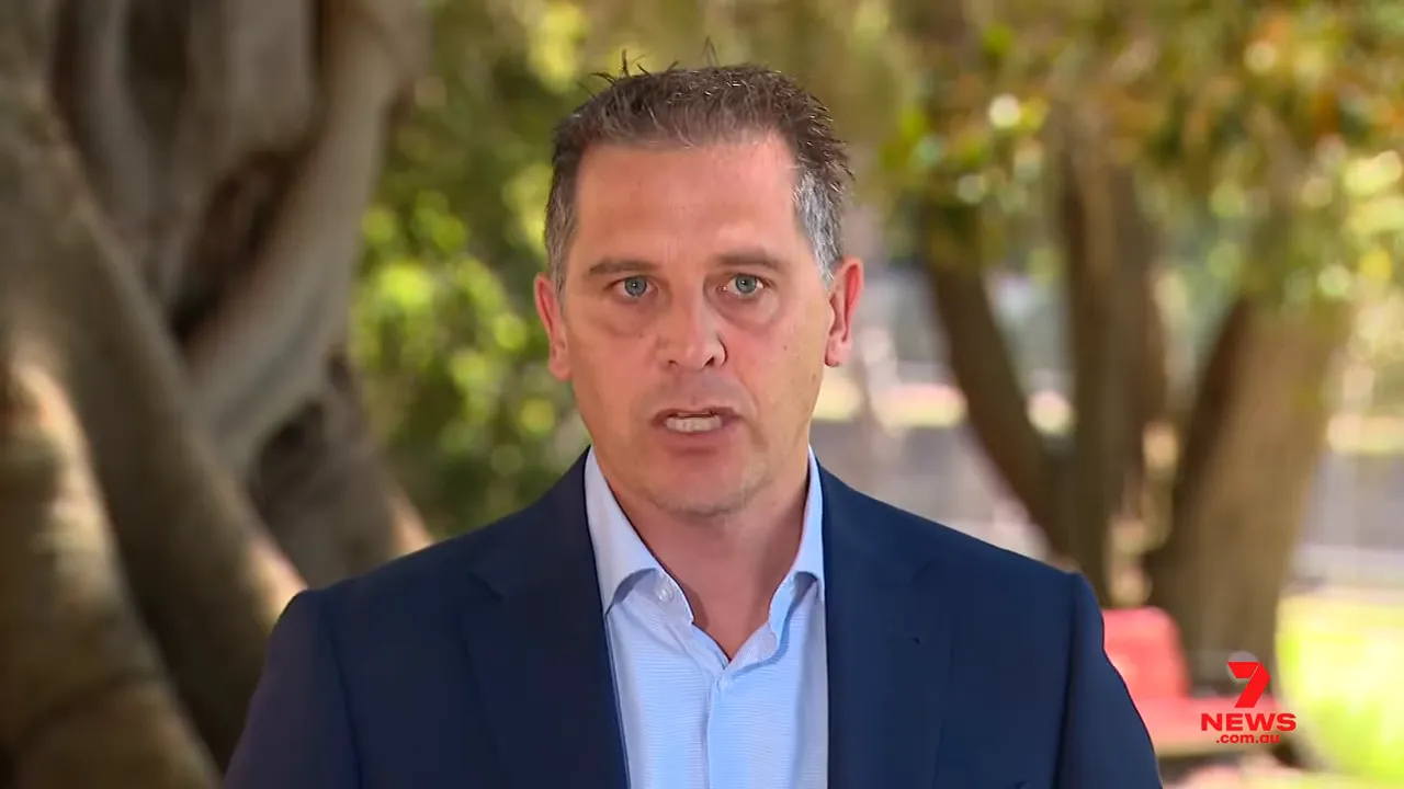 Clear, centered shot of an official speaking outdoors about emergency health preparations for extreme heat