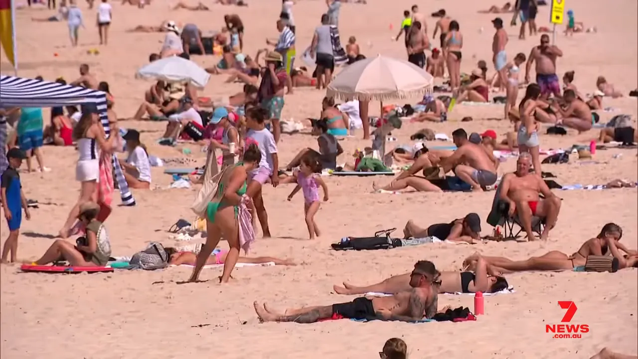 Close view of many people sunbathing and gathering on a crowded beach during hot weather