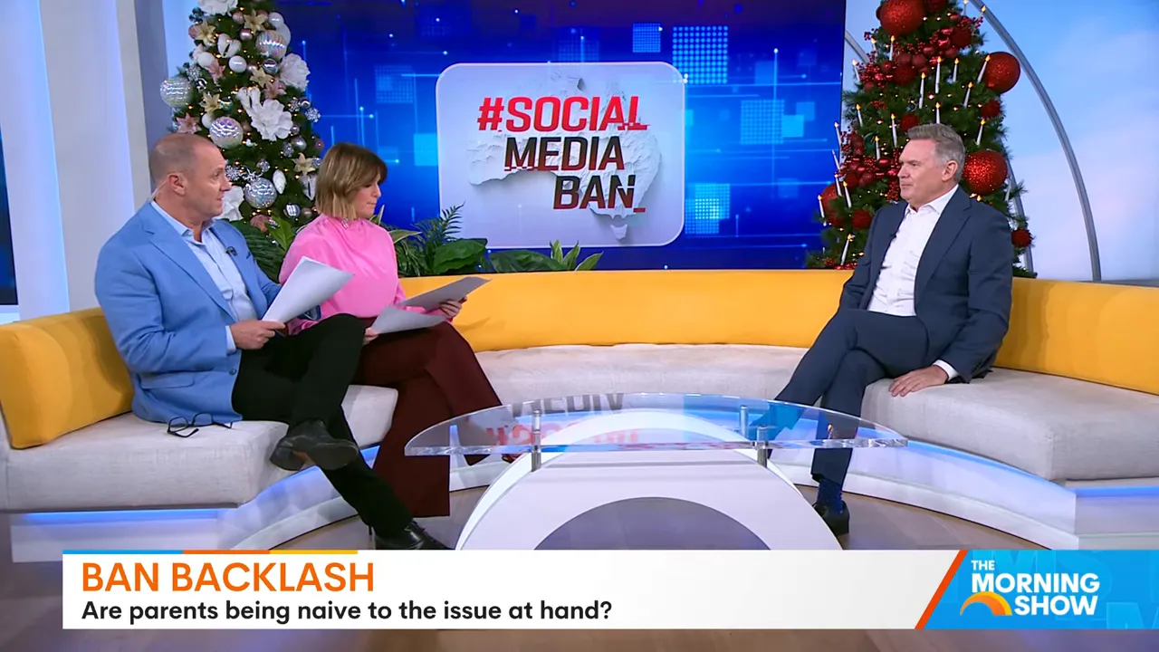 Wide, high-quality studio shot showing two hosts and a guest with a prominent '#SOCIAL MEDIA BAN' graphic on the screen behind them