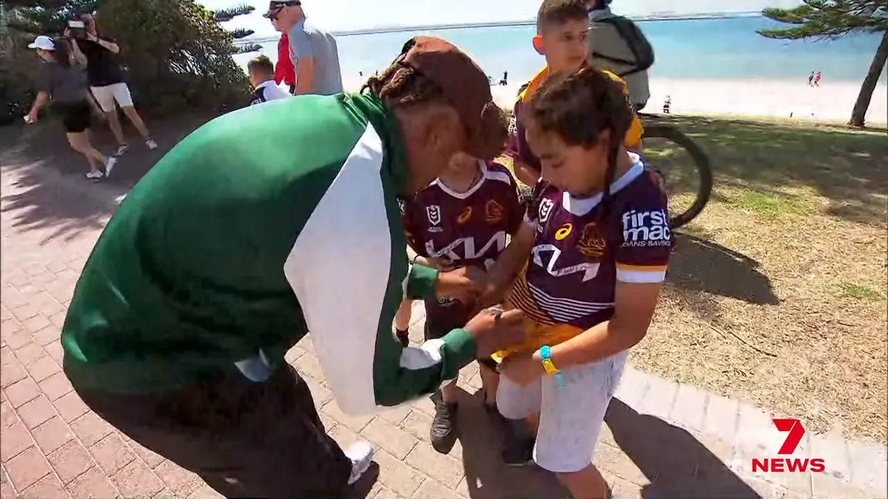 Broncos players signing autographs on the beach