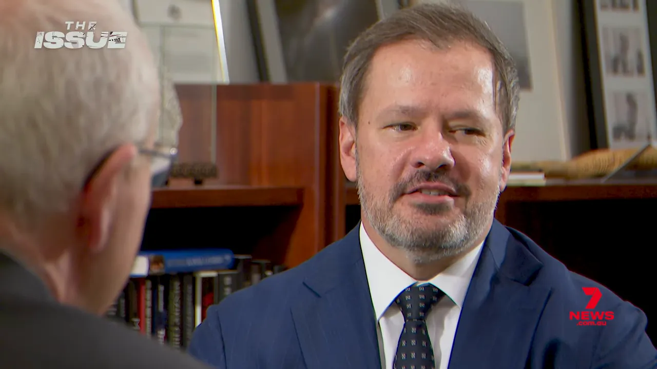 Member of parliament in suit mid-conversation during a televised interview about AI policy