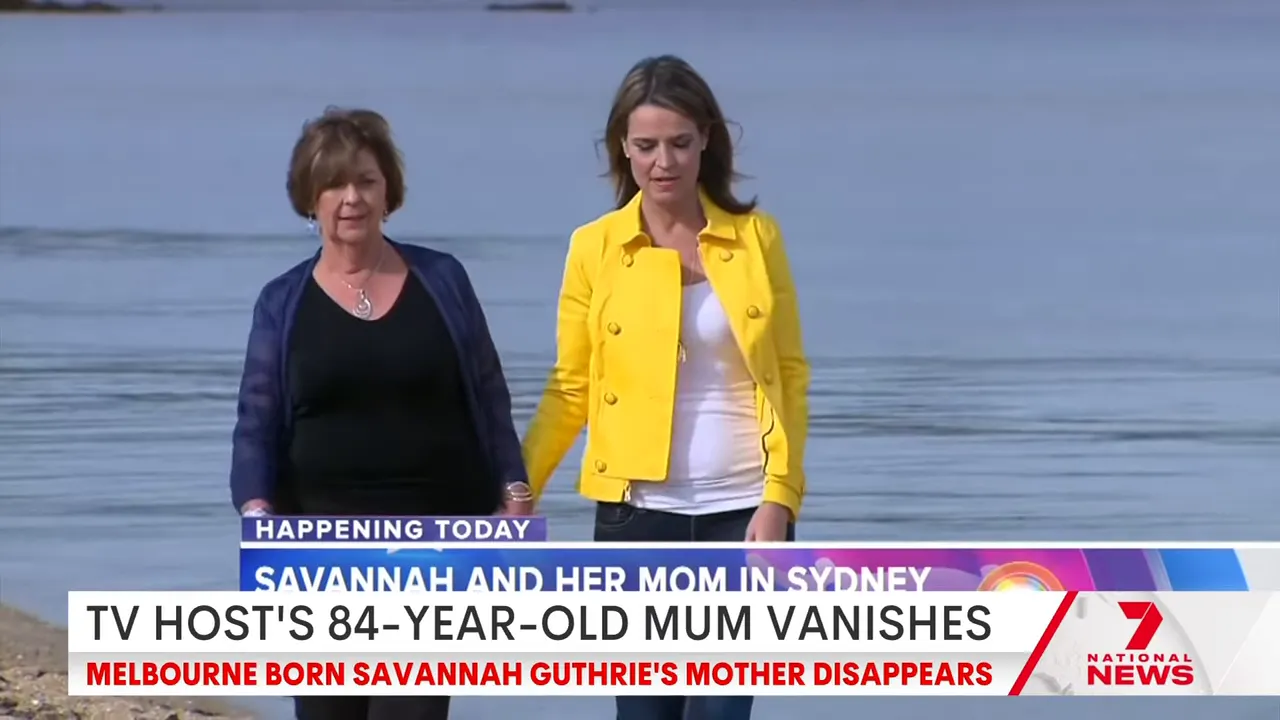 TV host and her mother walking along a beach shoreline with calm water in the background and a news chyron at the bottom.