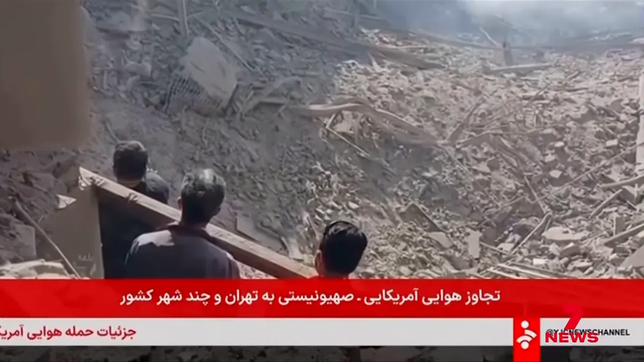 People standing at the edge of widespread rubble and collapsed structures, surveying the damage at a strike site.