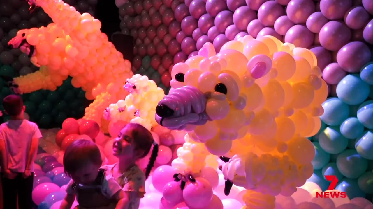Large, colourful balloon animal sculptures with children and visitors in the foreground