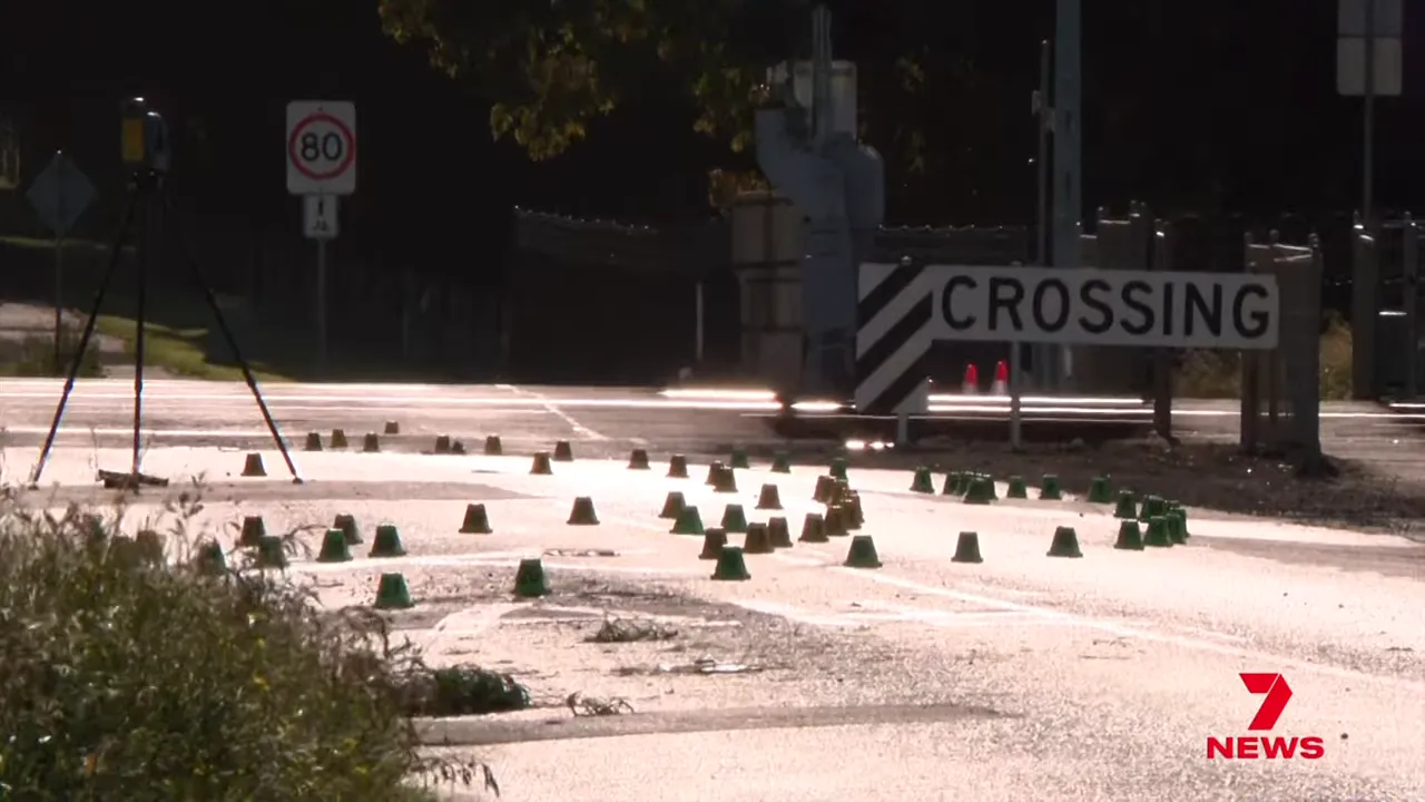 Forensic markers and cones on road near a railway crossing at the crash scene