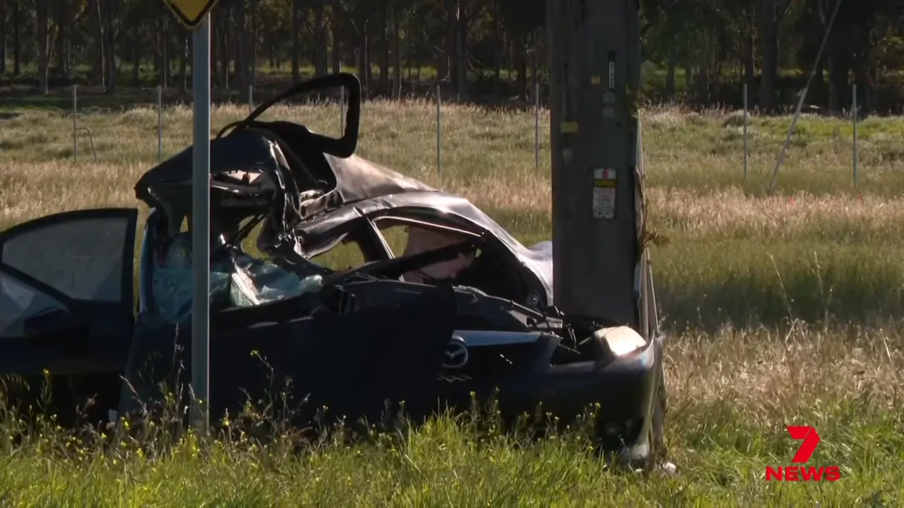 Crashed Mazda wrapped around a power pole on School Road with severe roof and front-end damage