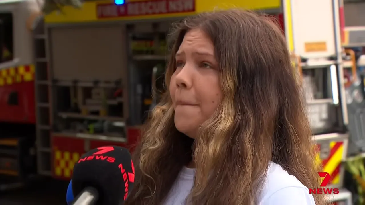 Witness speaking in front of a rescue truck and microphone during the South Coogee fire response