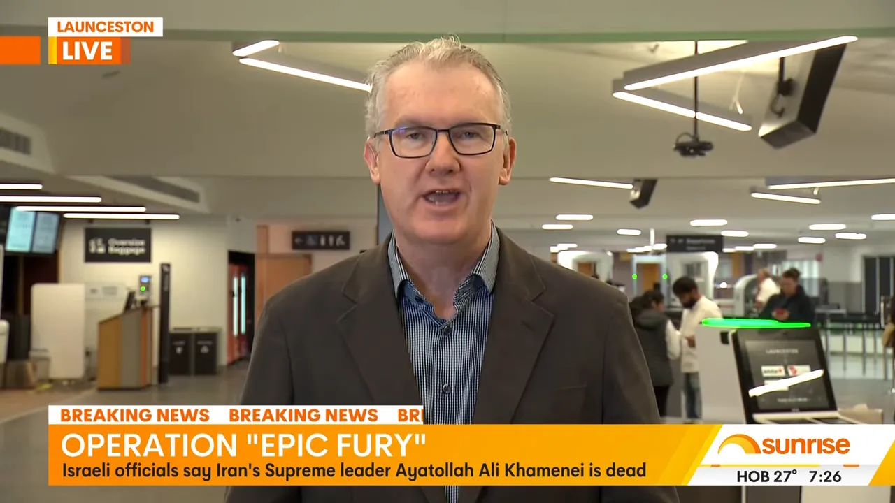 Live television report in an airport terminal with visible security screening area behind the correspondent.