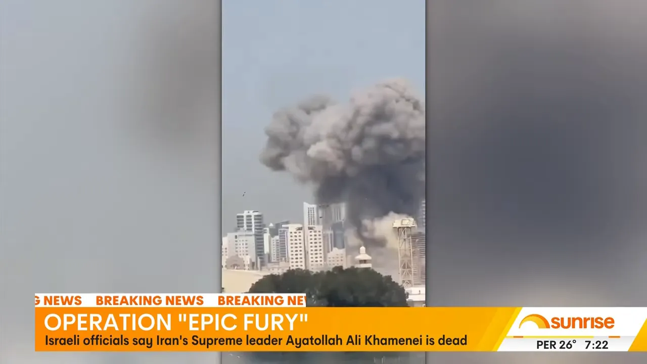 Large mushroom-like cloud of smoke rising over a city skyline during daytime, with a breaking news banner about Operation 'EPIC FURY'.