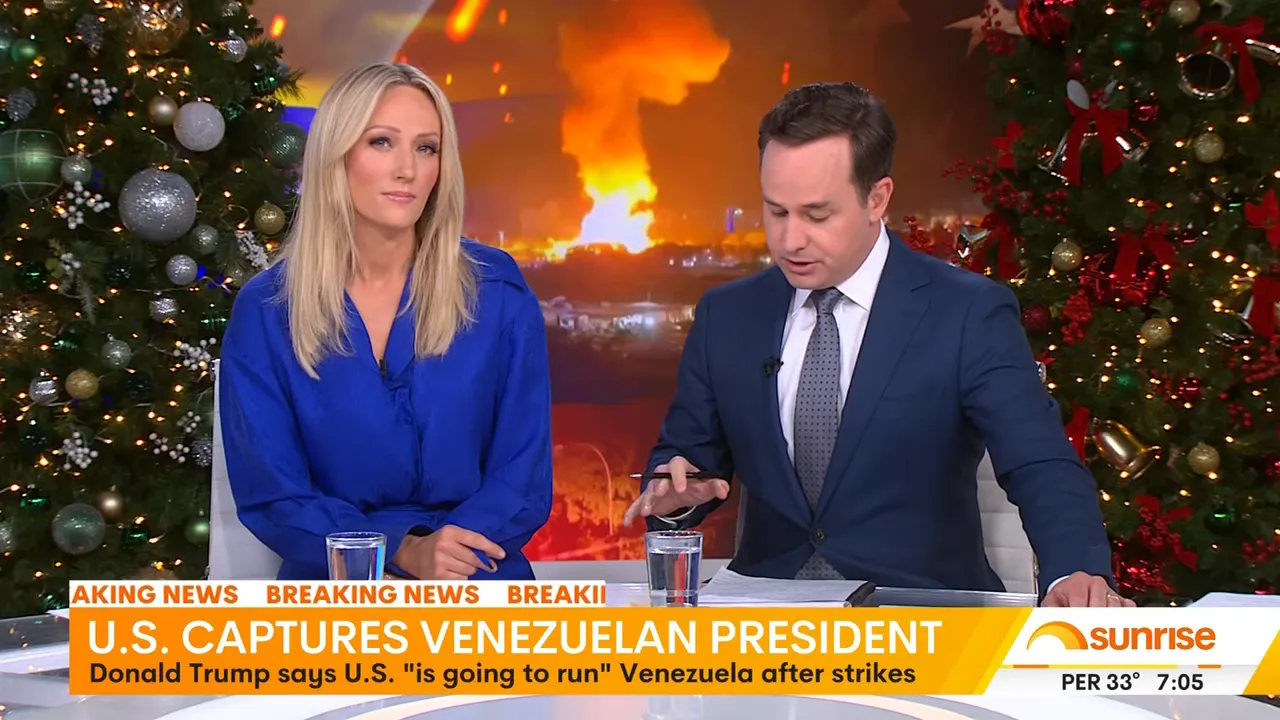 Wide shot of two news anchors at the desk with a large blaze or explosion on the screen behind them and an orange breaking-news chyron.