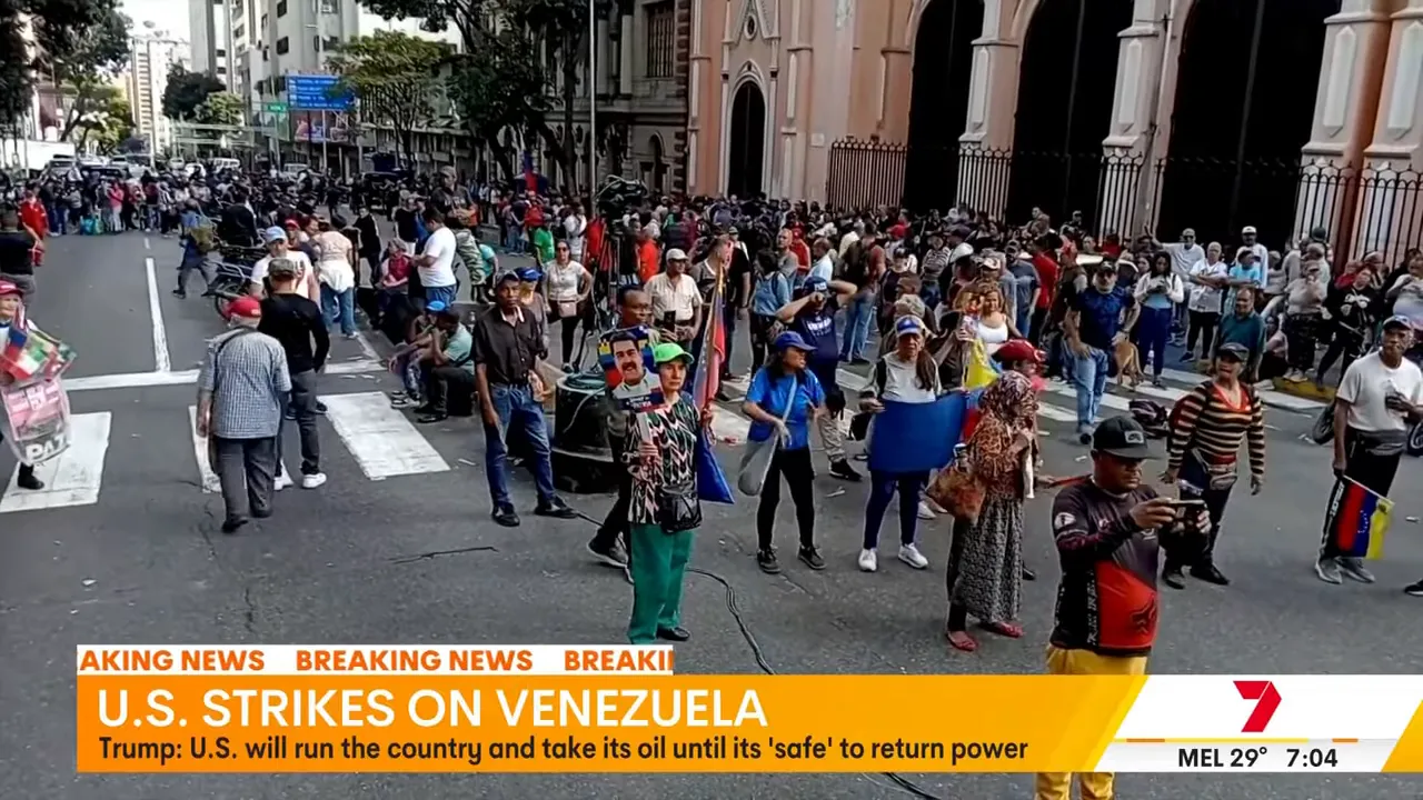 Wide crowd in central Caracas on a city street with Venezuelan flags and onlookers
