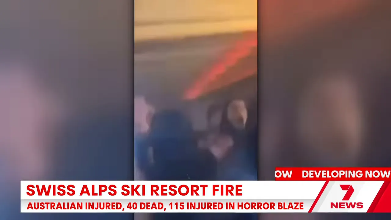 Vertical video screenshot showing a crowd inside the bar and a red‑orange glow along the ceiling consistent with flames and smoke.