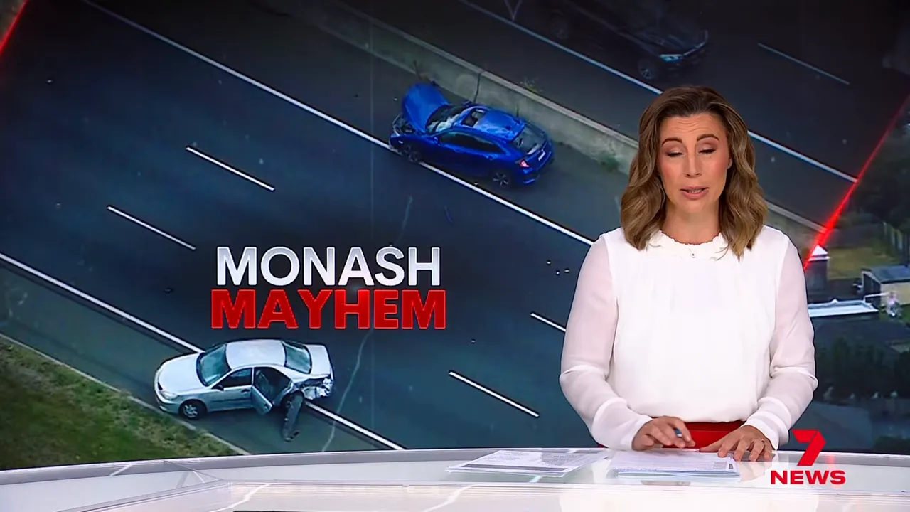 news anchor with aerial view of two crashed cars on the Monash Freeway and a 'Monash Mayhem' headline