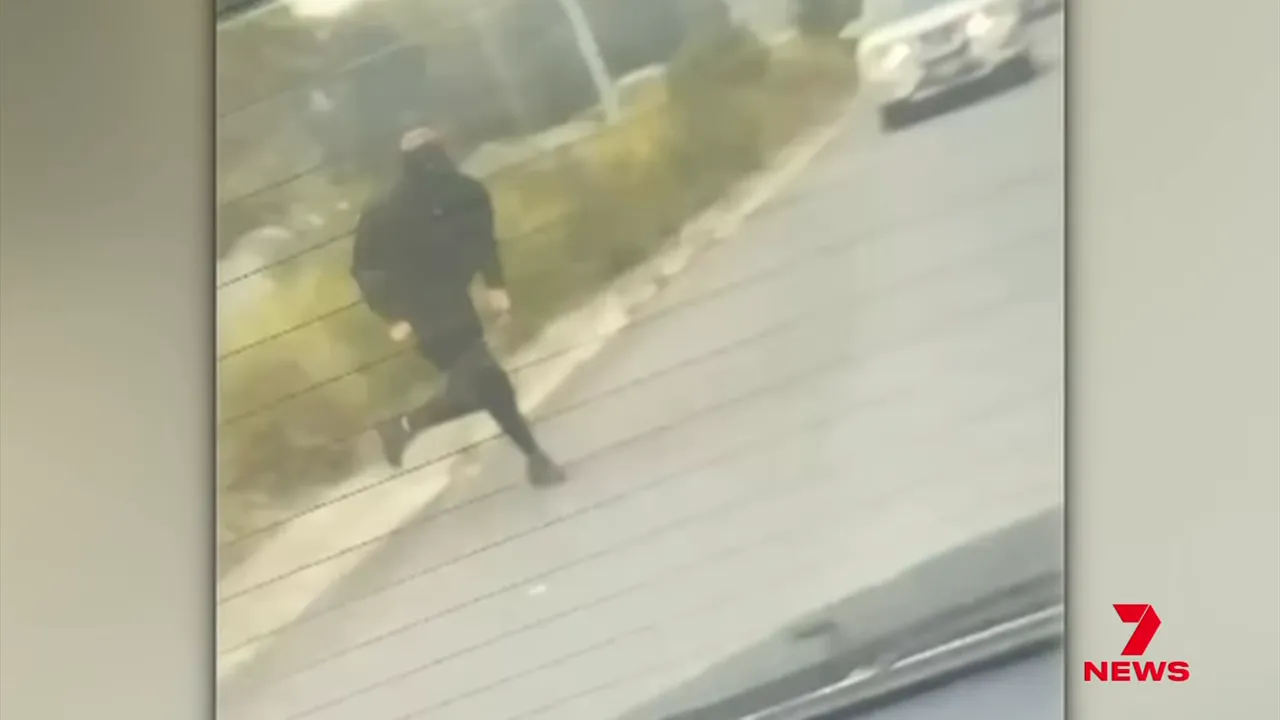 masked person in black clothing on the Monash Freeway ramp captured on video