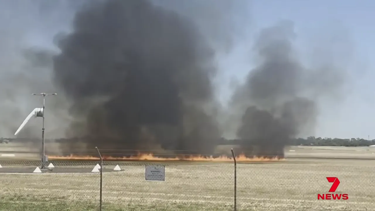 Large plumes of black smoke and grass fire at Parafield Airport after crash