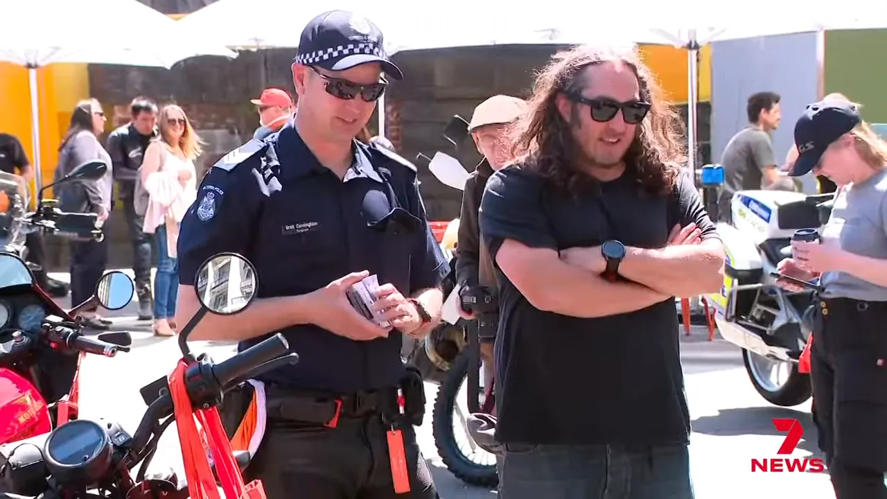 Ross Noble and Sergeant Brett Cunningham talking by police motorcycles