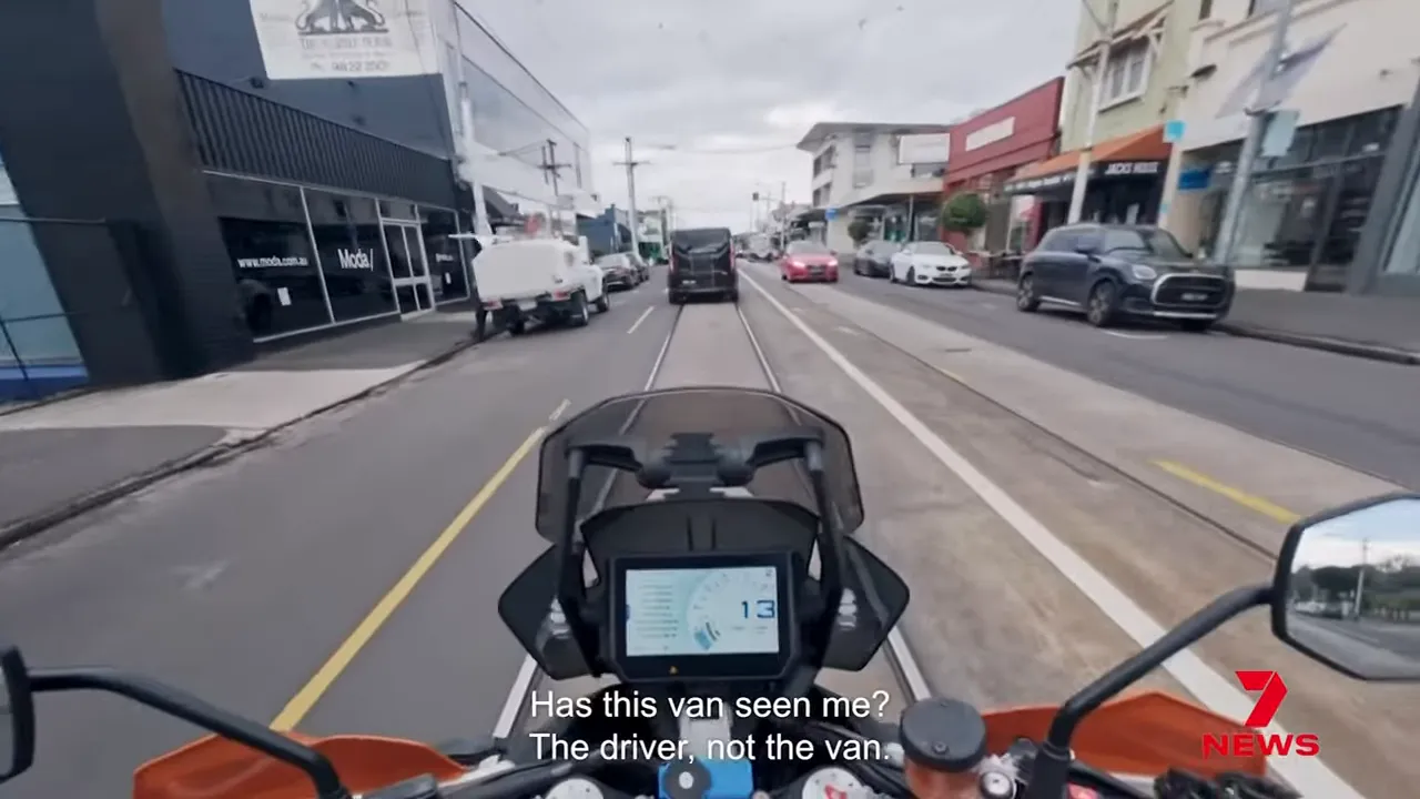 Ross Noble riding past a white van in the ad