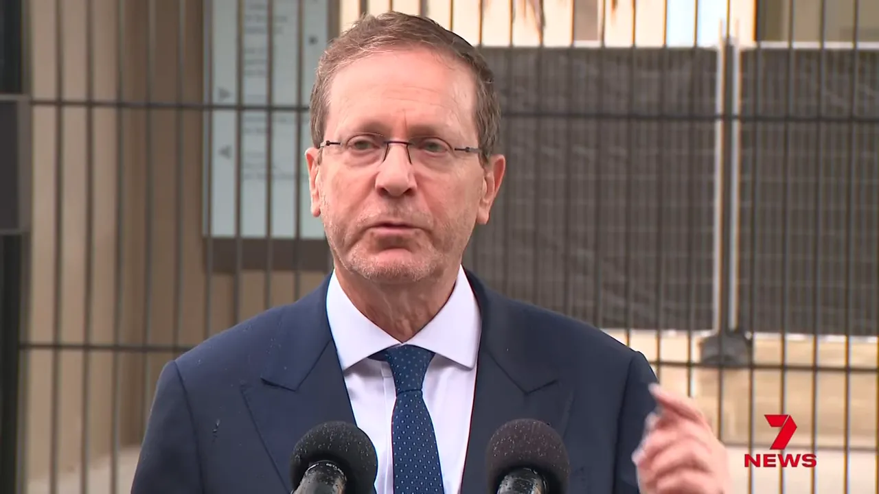 frontal view of an official speaking at a memorial with microphones in foreground