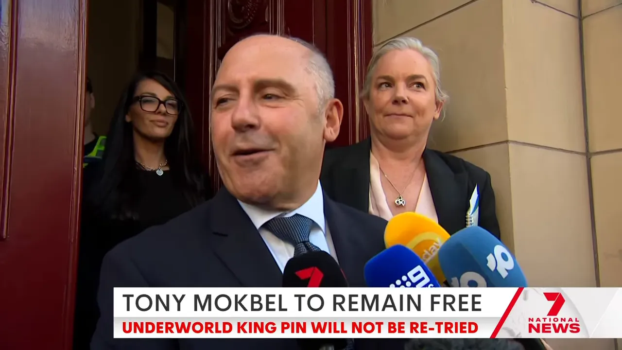 Tony Mokbel speaking into several news microphones on the courthouse steps, clear and well-lit